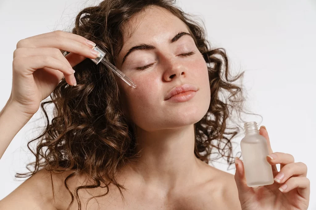 immagine ragazza che applica il siero viso all'acido ialuronico